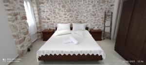 沃丽曼村Xenonas "Alexandra's Coffee House"的一间卧室配有带白色床单和枕头的床。