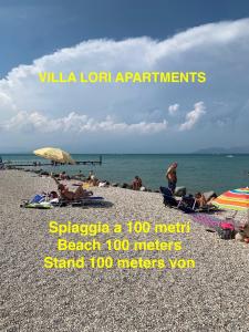 佩斯基耶拉德加达Villa Lori Apartments Garden and Beach的一群人,在海边