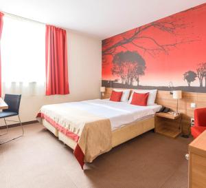 布达佩斯议会酒店的酒店客房设有一张床,墙上挂有红色的画作