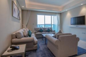 迪拜Jood Hotel Apartments的客厅配有2张沙发和1台平面电视