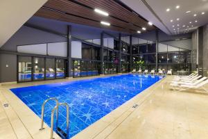马尼萨四十五商务酒店及Spa的大楼内带椅子的大型游泳池
