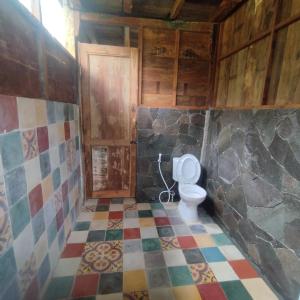 PablenganKebun Hanoman Villa的一间带卫生间的浴室和瓷砖地板。