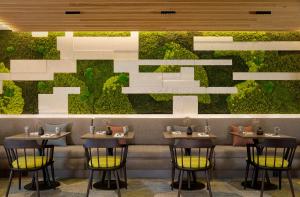 史基浦Sheraton Amsterdam Airport Hotel and Conference Center的餐厅设有4张桌子和绿色的墙壁