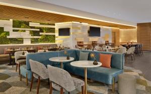 史基浦Sheraton Amsterdam Airport Hotel and Conference Center的餐厅设有蓝色的沙发和桌椅