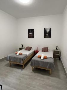 里斯本Oriente DNA Studios IV的一间卧室配有两张床、两张桌子和两面镜子