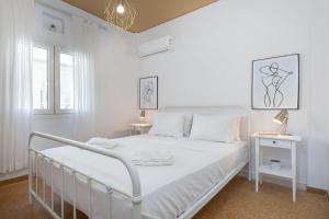 雅典Breeze 1BD Apartment by BluPine的白色卧室配有白色的床和2张桌子