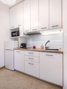 雅典Breeze 1BD Apartment by BluPine的白色的厨房配有白色橱柜和水槽
