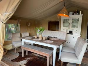 皮滕Het Blauwe Huysch的帐篷内的用餐室配有桌椅