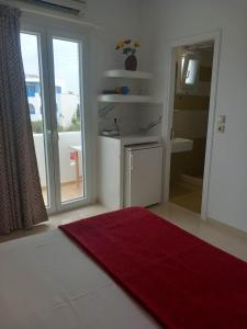 阿吉奥斯普罗科皮奥斯克里马塔利亚公寓的一间带红色地毯的浴室和一间带水槽的浴室