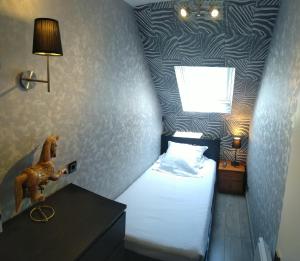 图克L'échappée belle的一间小卧室,配有一张墙上的马床