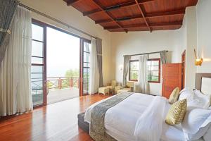 KisoroGorilla Heights Lodge的一间带大床的卧室和一个阳台