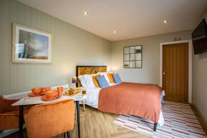 WinsterComfy Lake District Cabins - Winster, Bowness-on-Windermere的一间卧室配有一张床和一张桌子