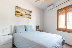 塔马留Seamount, a beautiful house overlooking Tamariu的白色的卧室设有床和窗户