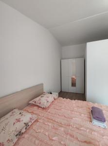 拉斯托伏Apartmani Lešić Zaklopatica的一间卧室配有一张带粉色床单和镜子的大床