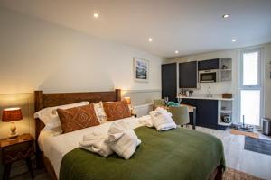 WinsterComfy Lake District Cabins - Winster, Bowness-on-Windermere的卧室配有毛巾,位于床上