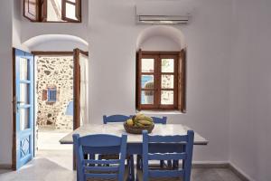 费拉Amphitheater Cave Houses的一间带桌子和蓝色椅子的用餐室