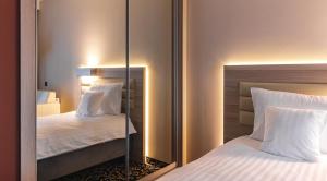 博茨科沃Antonińska Resort SPA的配有2张床的酒店客房内的镜子