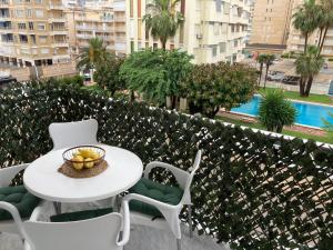 甘迪亚海滩Apartament Bari Playa的阳台上的桌椅和一碗水果