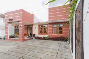 巴图RedDoorz at WR Supratman Batu的红色和白色外墙的房子