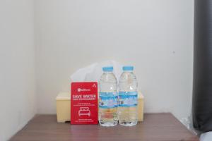 巴图RedDoorz at WR Supratman Batu的桌子上放着两瓶水