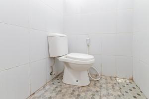 巴图RedDoorz at WR Supratman Batu的白色瓷砖客房内的卫生间