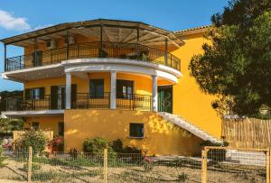 阿凯松Kotrona Farmhouse - Argassi Zakynthos的黄色房子的顶部设有阳台
