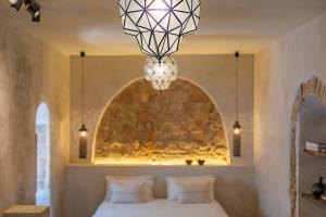 塔里法The Riad - Adults Only的一间卧室配有一张床和一个吊灯