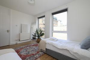 伦敦Stay in Islington in style 3BDR apt Nr Upper St的一间卧室设有两张床和大窗户