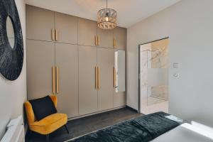 Domaine Grand Piquecaillou - L'appartement Sauternes的一间卧室配有一张床、椅子和橱柜