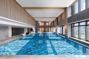 武汉武汉光谷万豪酒店的蓝色建筑中的一个大型游泳池