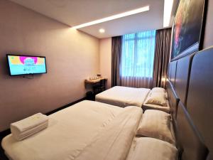 古来Zenz Hotel的一间酒店客房,设有三张床和一台平面电视