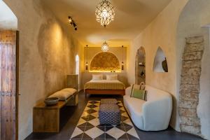 塔里法The Riad - Adults Only的一间卧室配有一张床、一张沙发和一张桌子
