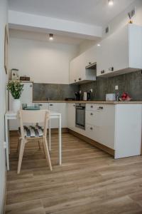 哈日科维Stylowe apartamenty的厨房配有白色橱柜、桌子和椅子
