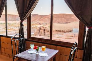 阿伊特本哈杜Palais Ksar Lamane的一张桌子,放两杯葡萄酒,欣赏沙漠美景