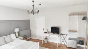 锡厄姆LONDONDERRYS Bar and Accommodation的白色的客厅配有床和电视。