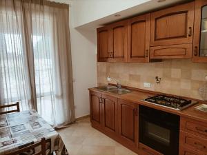 福利尼奥Casa Emilia - Appartamento per vacanze - Foligno的厨房配有木制橱柜、水槽和桌子