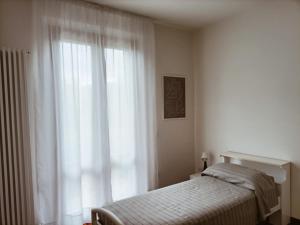 福利尼奥Casa Emilia - Appartamento per vacanze - Foligno的一间卧室设有一张床和一个大窗户