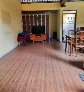 马格朗Anindya House的客厅铺有木地板,配有电视。
