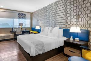 萨凡纳GLō Best Western Savannah-Gateway I-95的酒店客房设有一张大床和一张书桌。