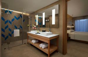 斋浦尔Hyatt Place Jaipur Malviya Nagar的一间带水槽和镜子的浴室以及一张床