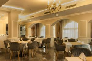 瓦尔纳Vemara City Apart Hotel的一间带桌椅和吊灯的餐厅