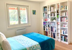 罗勒Les oliviers的一间卧室,书架上摆放着书籍