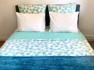 罗勒Les oliviers的一张带两个枕头和蓝色棉被的床