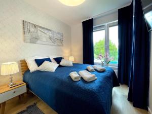 科沃布热格Klif Apartamenty Nadmorskie Tarasy的一间卧室配有蓝色的床和两个枕头