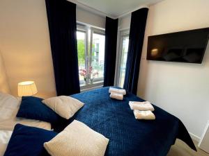 科沃布热格Klif Apartamenty Nadmorskie Tarasy的一间卧室配有蓝色的床和2条毛巾