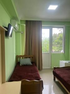 乌雷基Hotel Lotus的一间卧室设有一张床、一台电视和一个窗口。