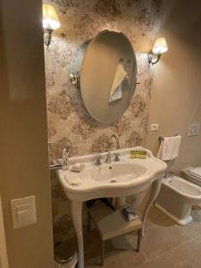 卢卡拉波耶梅酒店的一间带水槽、镜子和卫生间的浴室