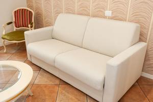维罗纳Residenza Catullo - Apartments的一张白色沙发,位于带桌子的房间