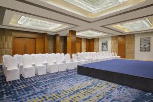 卡兰古特Fairfield by Marriott Goa Calangute的一间会议室,配有蓝色的桌子和白色的椅子