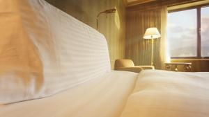 阿拉木图阿拉木图洲际酒店的卧室设有一张白色大床和一扇窗户。